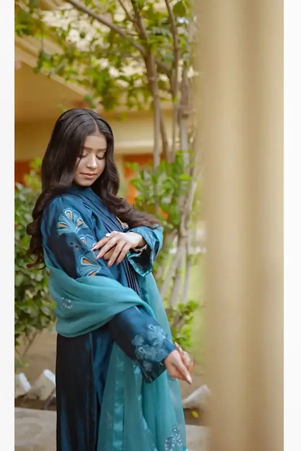 Model in Teal Blossom Ladies Dress displaying side profile with intricate floral details, from Saanah traditional collection.