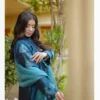 Model in Teal Blossom Ladies Dress displaying side profile with intricate floral details, from Saanah traditional collection.