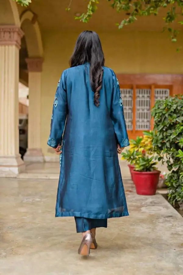 Model wearing Teal Blossom Ladies Dress highlighting back design with floral embroidery, from Saanah ladies clothing.