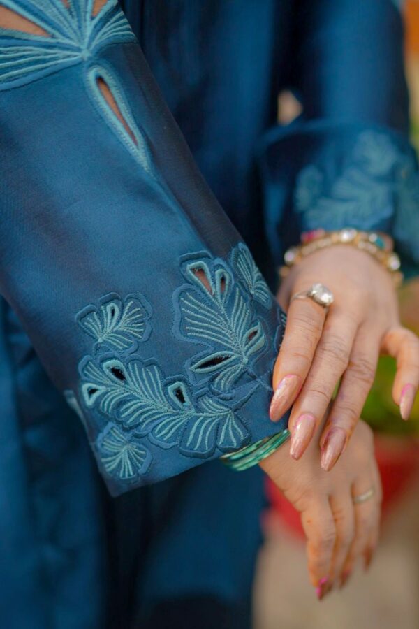 Close-up of Teal Blossom Ladies Dress on model, focusing on floral embroidery details, from Saanah traditional wear collection.