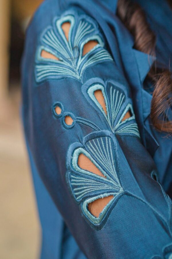 Close-up of Teal Blossom Ladies Dress on model, focusing on floral embroidery details, from Saanah traditional wear collection.