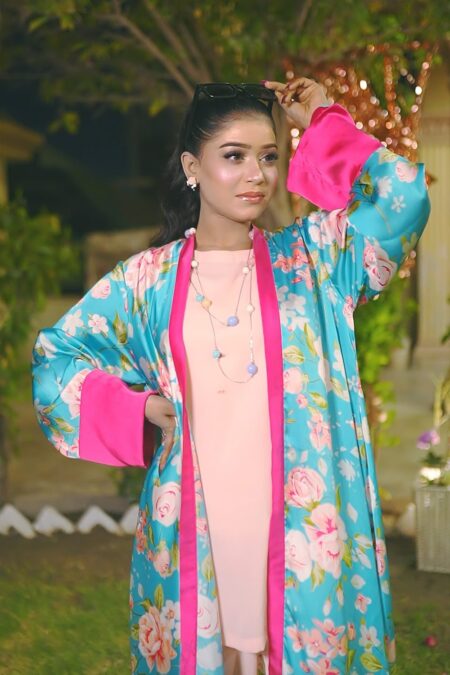 Front view of a woman in the Saanah Blossom Breeze Silk Shrug Set, showcasing a peach blush cami and culottes with a teal floral shrug.