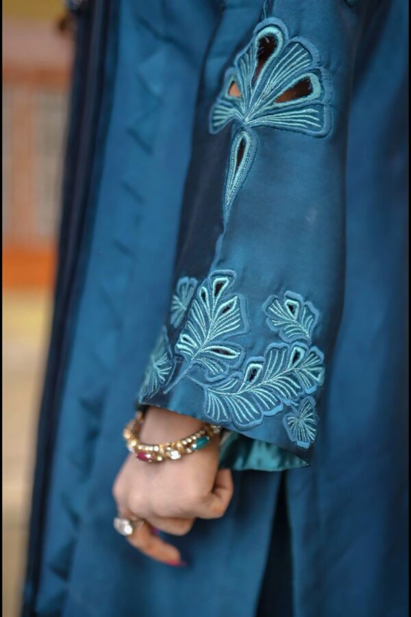 Model in Teal Blossom Ladies Dress displaying side profile with intricate floral details, from Saanah traditional collection.