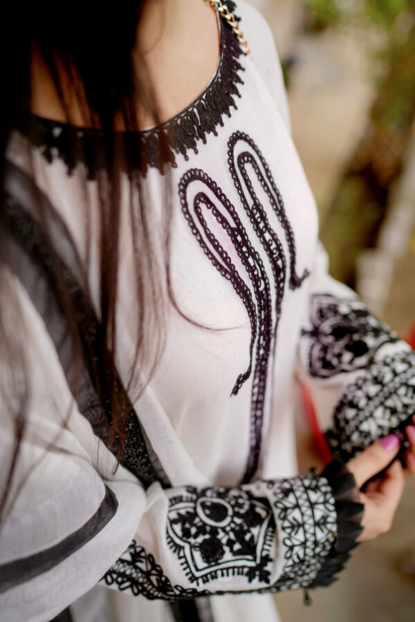 Close-up of Shan-e-Zar: White Elegance Unleashed on model, focusing on floral embroidery details, from Saanah ladies clothing collection.