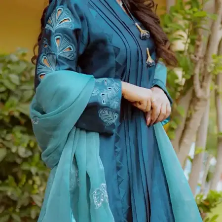 Model wearing Teal Blossom Ladies Dress with floral embroidery, showcasing traditional style from Saanah ladies clothing collection.