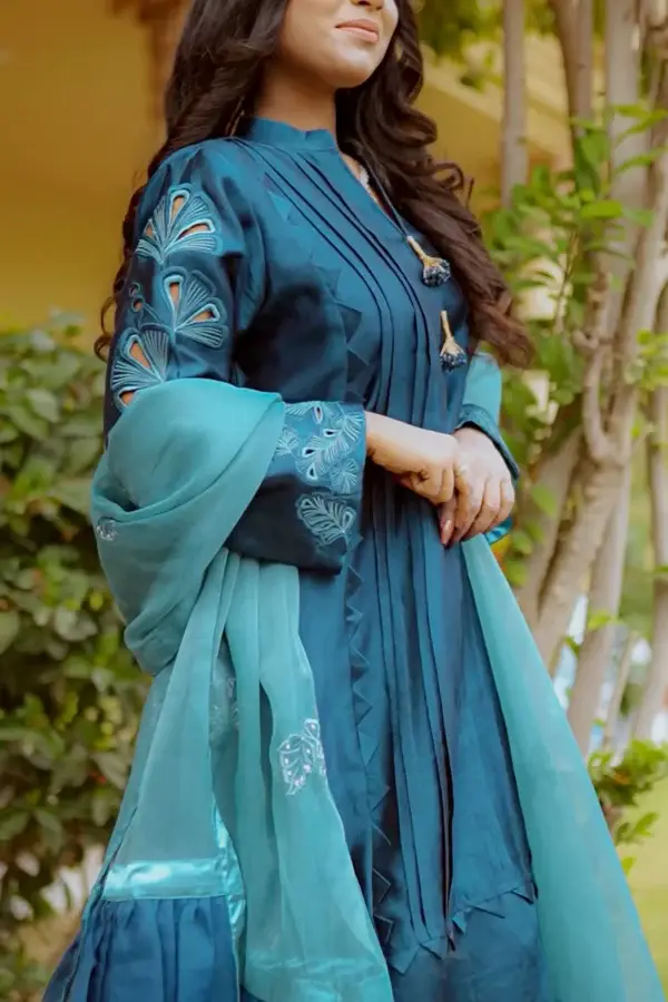 Model wearing Teal Blossom Ladies Dress with floral embroidery, showcasing traditional style from Saanah ladies clothing collection.