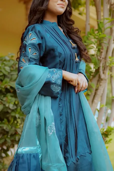 Model wearing Teal Blossom Ladies Dress with floral embroidery, showcasing traditional style from Saanah ladies clothing collection.