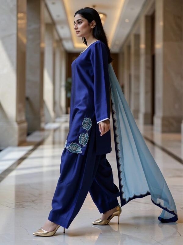Side profile showing embroidered hem and scalloped medium silk dupatta.